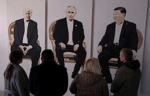 Visitors stand in front of an artwork depicting U.S. President Donald Trump, Russian President Vladimir Putin and Chinese President Xi Jinping at an exhibition at an art gallery in Livadia park in Yalta, Crimea, Feb. 8, 2025.