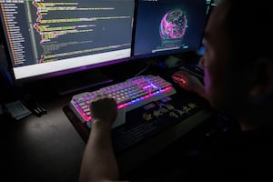 This photo taken on Aug. 4, 2020 shows Prince, a member of the hacking group Red Hacker Alliance who refused to give his real name, using a website that monitors global cyberattacks on his computer at their office in Dongguan, China's southern Guangdong province.