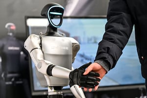 A man shakes hands with a humanoid robot from Unitree Robotics during the Global Developer Conference, organized by the Shanghai AI Industry Association, in Shanghai on Feb. 21, 2025.